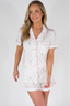 Model showcases matching white pajama set with multicolored bottles printed.