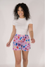 Model in a white t-shirt with purple boxer shorts with multicolor pattern.