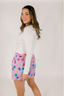 Model with white long sleeve shirt and purple boxer short with multicolor pattern.