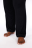 Woman wearing black luxury pajamas on a white background