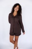 Model standing in chocolate brown pajama with long sleeves and shorts.