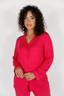 Woman wearing a bright pink pajama set against a white background