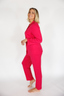 Woman wearing a bright pink outfit on a white background