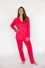 Woman wearing a bright pink pajama set on a white background