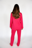 Person wearing a bright pink pajama set on a white background