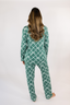Model standing backwards showing a matching green pajama set with geometric bow pattern.