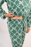 Model showing waistband of green matching pajama set with geometric bow pattern.