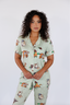Model standing in sage green pajamas with duck print.