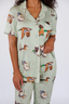 Model standing in sage green pajamas with duck print.
