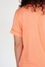 Person wearing an orange pajama top on a plain background