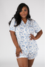A woman modeling a short sleeve and short pajama set with a white and blue Happily Ever After print.