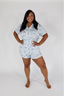 A woman modeling a short sleeve and short pajama set with a white and blue Happily Ever After print.