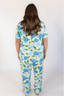 A woman wearing a short sleeve and cropped pant pajama set with a hydrangea bloom print.