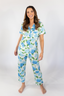 A woman wearing a short sleeve and cropped pant pajama set with a hydrangea bloom print.