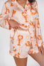 Person wearing a pajama set with orange lobster pattern on a white background
