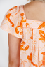 Woman wearing a dress with orange lobster pattern on a white background