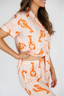 Woman wearing a outfit with orange lobster print on a white background