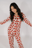 A woman wearing a long sleeve and pant pajama set with a red rose pattern on a white background.