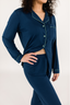 Model showing the waistband of the matching navy blue pajama set with empire green piping.
