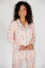 Woman wearing a patterned pajama set against a white background