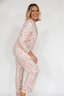 Woman wearing a floral pajama set against a white background