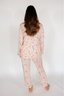 Person wearing a floral pajama set on a white background