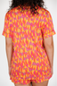 Person wearing a colorful patterned outfit with orange and pink design.