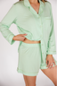 Light green pajama set worn by a person on a white background