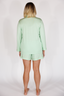 Person wearing a light green pajama set on a white background