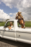 Two people in a white truck with a scenic background