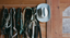 Horse bridles and a hat hanging on a wooden wall