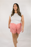 Model standing in white t-shirt with pink striped boxer shorts.