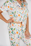 Person wearing a colorful fruit-patterned outfit on a white background