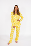 Woman wearing yellow star-patterned pajamas on a white background