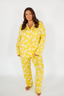 Woman wearing yellow star-patterned pajamas on a white background
