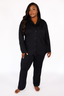 Woman wearing black luxury pajamas on a white background