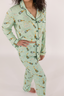 Model showing the waistband of the light green matching pajama set with yellow champagne bottles. 