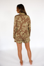 Woman wearing a luxury pajama set with brown and lime punch paisley pattern on a white background