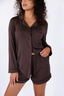 Model standing in chocolate brown pajama with long sleeves and shorts.