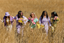 Five women in modal pajama sets walking through a spring field. 