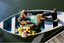 A woman lying in a small boat wearing a short sleeve and short modal pajama set surrounded by spring flowers.