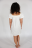 Woman wearing a white nightgown against a plain background
