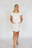 Woman wearing a white dress with a plain background