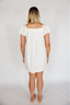Woman wearing a white nightgown against a plain background