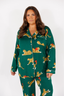 Woman wearing a green pajama set with animal prints on a white background