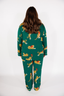 Person wearing a green pajama set with animal print on a white background