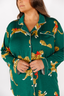 Green pajama top with leopard print pattern on a white background