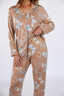 Model standing in light brown pajama set with hats and horseshoe icons.