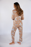 Model standing in light brown pajama set with hats and horseshoe icons.