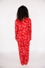 Person wearing a red pajama set with white bows on a white background